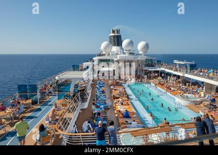 Bateau de croisière en mer, avec de nombreux vacanciers à la piscine. Banque D'Images