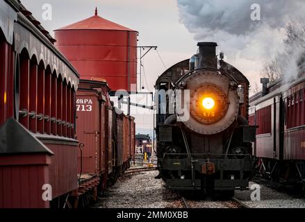 Strasburg, Pennsylvanie, 27 décembre 2022 - Vue sur un train de voyageurs à vapeur classique arrivant dans une gare qui soufflait de fumée et de vapeur, le jour d'hiver Banque D'Images