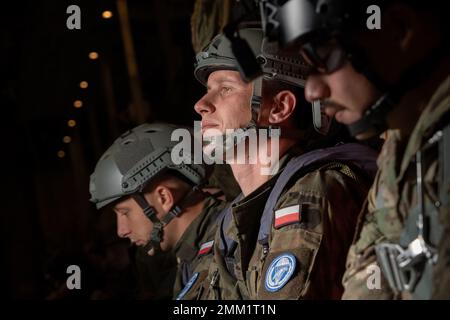Les membres de la Force aérienne des États-Unis et de la force terrestre polonaise attendent d'effectuer une descente d'air statique à partir d'un avion C-130J Super Hercules, affecté au 37th Escadron de transport aérien de la base aérienne de Ramstein, en Allemagne, dans le cadre de l'entraînement de rotation 22-4 (ADR 22-4) du détachement d'aviation, au-dessus de la zone de chute de Bledowska, en Pologne, le 13 septembre 2022. La participation à des événements de formation comme l'ADR 22-4 améliore les relations professionnelles et améliore la coordination globale avec les alliés et les militaires partenaires. Banque D'Images