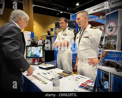 KISSIMMEE, Floride (sept 14, 2022) le lieutenant Rafae Khan et le lieutenant Brian Willima, tous deux affectés au Centre de recherche médicale navale (CNMV), parlent aux participants du Symposium de recherche sur le système de santé militaire (MHSRS). Le NMRC, qui fait partie de l’entreprise de recherche et développement médicaux de la Marine, a assisté au MHSRS, la première réunion scientifique du ministère de la Défense qui se concentre spécifiquement sur les besoins médicaux uniques du Warfighter. Ce symposium éducatif annuel réunit des professionnels de la santé, des chercheurs et des leaders du Département du développement pour quatre jours d'apprentissage critique, de partage intensif d'idées et de développement de relations. Banque D'Images