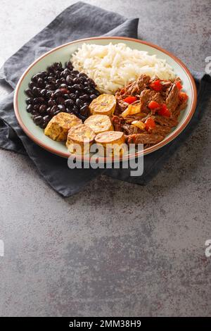 Pabellon criollo est un plat vénézuélien traditionnel fait avec du bœuf râpé qui est typiquement servi avec du riz blanc, des haricots noirs et des plantains frits cl Banque D'Images