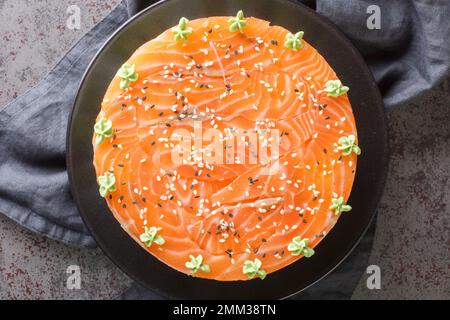 Gâteau de sushi au saumon, au riz, à l'avocat et au fromage de philadelphie, sur l'assiette de la table. Vue horizontale du dessus Banque D'Images