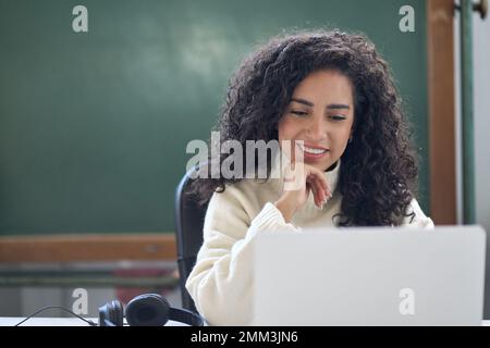 Jeune femme enseignant d'école, tuteur en ligne assis à un bureau enseignant à distance classe. Banque D'Images
