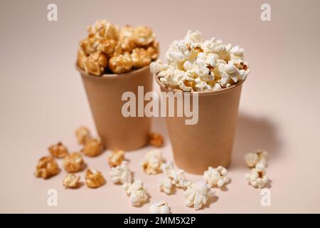 Deux types de pop-corn dans deux tasses en papier. Pop-corn salé et recouvert de Сaramel. Faible profondeur de champ. Banque D'Images