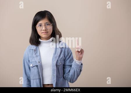 Une jeune femme mexicaine porte des lunettes, pointant vers le haut Banque D'Images