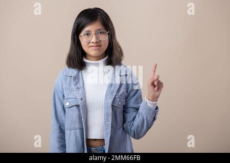 Une jeune femme mexicaine porte des lunettes, pointant vers le haut Banque D'Images