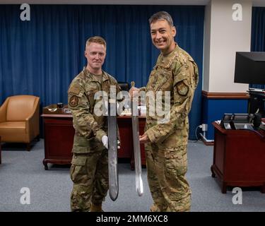 Le colonel Andrew Roddan, commandant de l’escadre du transport aérien 374th, et le sergent d’état-major. Michael Smith, artisan de la technologie des métaux de l'escadron de maintenance 374th, se présente avec la nouvelle épée de cérémonie de l'escadre à la base aérienne de Yokota, au Japon, le 15 septembre 2022. Smith a fait du bénévolat pendant plus de trois semaines pour créer l’épée cérémoniale. Banque D'Images