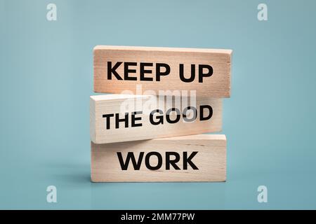 Continuez le bon travail, le texte est écrit sur des blocs de bois, le concept d'affaires, le slogan motivant, l'engagement de travail Banque D'Images