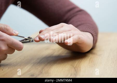 Gros plan des mains masculines coupant les ongles. Jeune bel homme se coupant les ongles Banque D'Images