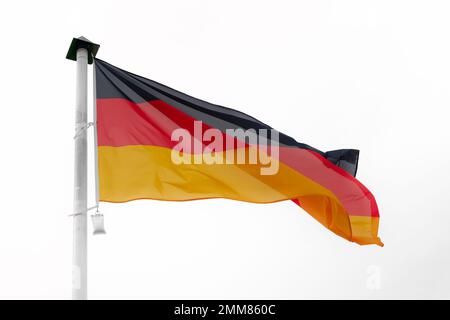 Drapeau allemand agitant dans le vent sur un mât avec un fond blanc Banque D'Images