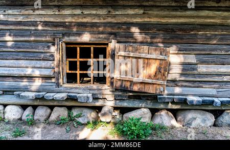 Petite fenêtre dans le mur de l'ancienne maison en bois. Maison en bois vintage avec petite fenêtre Banque D'Images