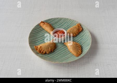 La vie de la dishe culinaire africaine. Beignets farcis aux pâtes avec sauce épicée Banque D'Images