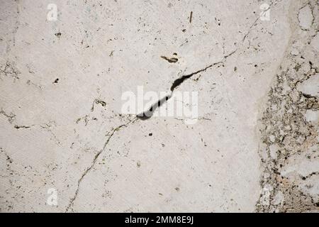 vieux mur de lumière en pierre de marbre avec des fissures et des trous comme arrière-plan, mur de maison en pierre, carreaux Banque D'Images