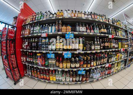 Italie - 9 septembre 2023: Bouteilles de liqueur, whisky, rhum et autres boissons alcoolisées en vente sur le plateau de supermarché italien, vision du poisson Banque D'Images