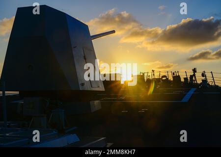 Le soleil se couche sur la proue du destroyer à missiles guidés de classe Arleigh Burke USS Shoup (DDG 86) alors qu'il est en cours dans l'océan Pacifique, le 15 septembre 2022. Shoup est en cours pour participer à un exercice Live Fire with A Purpose. Banque D'Images