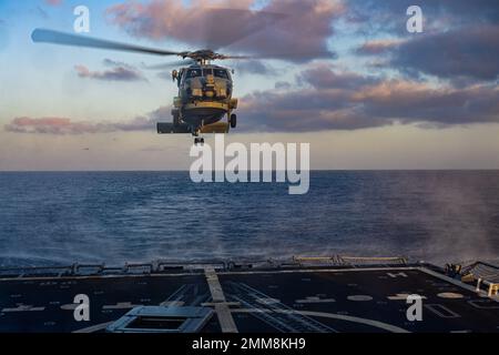 Un hélicoptère MH-60R Sea Hawk tente d'atterrir sur le destroyer à missiles guidés de classe Arleigh Burke USS Shoup (DDG 86) alors qu'il est en cours dans l'océan Pacifique, le 15 septembre 2022. Shoup est en cours pour participer à un exercice Live Fire with A Purpose. Banque D'Images