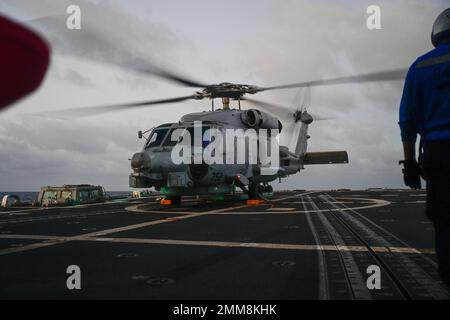 Un hélicoptère MH-60R Sea Hawk se prépare à décoller du destroyer à missiles guidés de classe Arleigh Burke USS Shoup (DDG 86) alors qu'il est en cours dans l'océan Pacifique, le 15 septembre 2022. Shoup est en cours pour participer à un exercice Live Fire with A Purpose. Banque D'Images