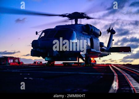 Un hélicoptère MH-60R Sea Hawk se prépare à décoller du destroyer à missiles guidés de classe Arleigh Burke USS Shoup (DDG 86) alors qu'il est en cours dans l'océan Pacifique, le 15 septembre 2022. Shoup est en cours pour participer à un exercice Live Fire with A Purpose. Banque D'Images