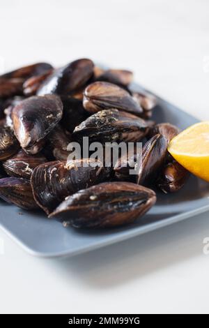 Gros plan d'une assiette avec des moules fraîchement couchées sur la table à manger Banque D'Images