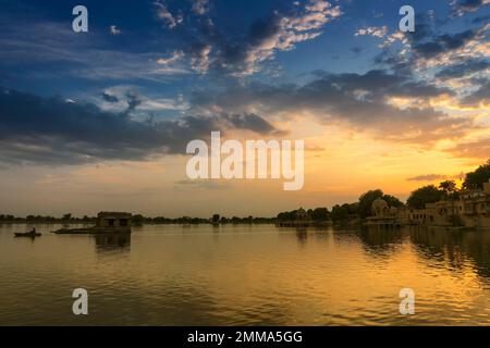 Coucher de soleil spectaculaire au lac Gadisar, Jaisalmer, Rajasthan, Inde. Soleil couchant et nuages colorés dans le ciel avec vue sur le lac Gadisar. Site touristique. Banque D'Images