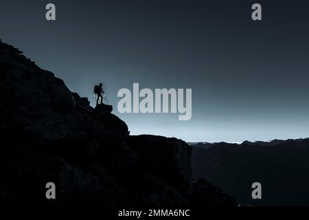 Mountaineer sur une corniche rocheuse avec contre-jour, montagnes du Tyrol du Sud en arrière-plan, Naturns, Tyrol du Sud, Italie Banque D'Images