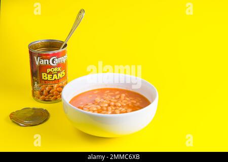 Boîte de Van camps porc et haricots les haricots cuits se démarquent sur un fond jaune dans un bol blanc Banque D'Images