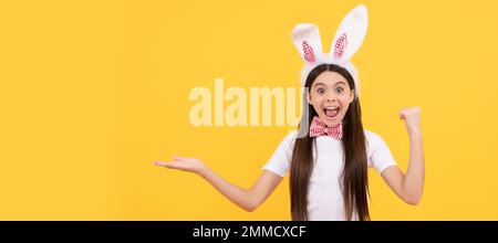 surprise enfant de pâques fille dans les oreilles de lapin présentant des ventes de shopping. Affiche horizontale pour enfant de Pâques. En-tête de bannière Web de bunny Kid, espace de copie. Banque D'Images