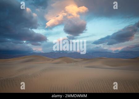 Les dunes de sable de Mesquite Flat commencent à briller lorsque le soleil se lève au-dessus de la vallée de la mort, en Californie. Banque D'Images