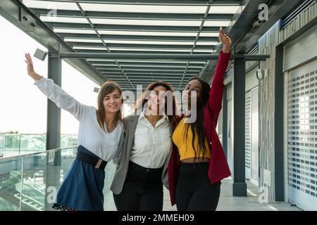 Trois jeunes femmes d'affaires célèbrent une réussite commerciale avec leurs bras levés Banque D'Images