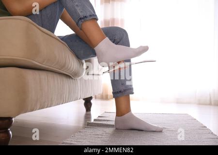 Femme qui pose une semelle intérieure orthopédique à la maison, en gros plan Banque D'Images