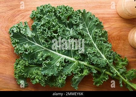 Chou frisé frais cru ou chou feuille (lat. Brassica oleracea) photographié au-dessus du bois Banque D'Images