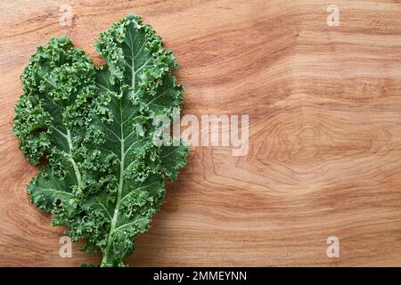 Chou frisé frais cru ou chou feuille (lat. Brassica oleracea) photographié au-dessus du bois (Focus sélectif) Banque D'Images