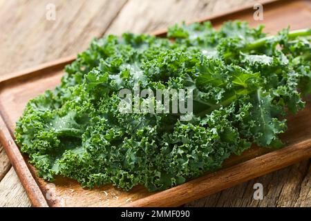 Chou frisé frais cru ou chou feuille (lat. Brassica oleracea) photographié sur bois (Focus sélectif) Banque D'Images