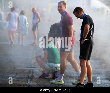 Les participants se rafraîchissez à une station de brumisation après avoir terminé le semi-marathon 2022 de la Force aérienne le 17 septembre, à la base aérienne Wright-Patterson, Ohio. Plus de 8 500 coureurs et 1 500 volontaires des 50 États et 18 pays différents sont venus courir pendant la course de 26th ans. Banque D'Images