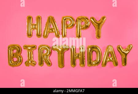 Expression JOYEUX ANNIVERSAIRE fait de lettres de ballon sur fond rose Banque D'Images