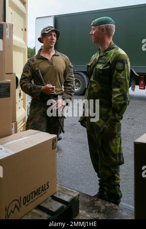 Sergent d'état-major des Marines des États-Unis Joseph Owen, commandant du peloton de reconnaissance mobile, 2D Bataillon de reconnaissance léger, et Sgt Martin Virtanen, sergent de peloton de missile Hellfire, 2D Bataillon marin suédois, distribuent des rations sur le terrain avant la phase d'exercice tactique de l'Archipel Endeavour 22 (AE22) sur la base navale de Berga, Suède, le 19 septembre 2022. AE22 est un exercice intégré de formation sur le terrain qui augmente la capacité opérationnelle et améliore la coopération stratégique entre les forces américaines Marines et suédoises. Banque D'Images