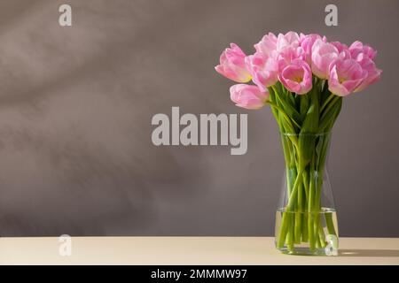 Tulipes roses dans un vase sur une table Banque D'Images