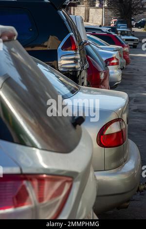 Gros plan de l'arrière, côté arrière de la voiture dorée avec d'autres voitures parking dans le parking extérieur en plein soleil. Banque D'Images