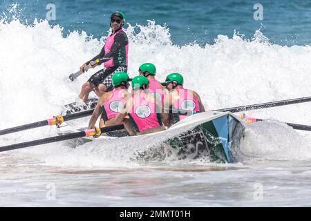 Sydney Northern Beaches Surfboat Carnival à North Narrabee Beach, Palm Beach SLSC hommes équipage de rangée vers la rive au-dessus des vagues de l'océan, Sydney, NSW, Aus Banque D'Images