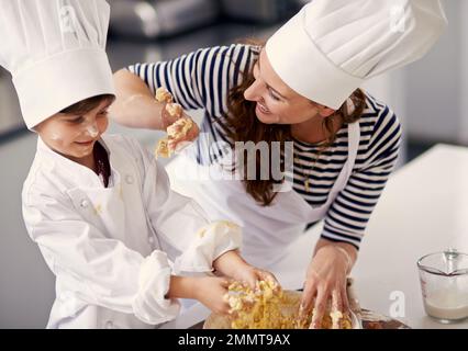 Les meilleures choses de la vie sont sucrées. une mère et son fils cuisant dans la cuisine. Banque D'Images