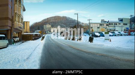 Route d'asphalte vide avec belle petite ville d'hiver Banque D'Images