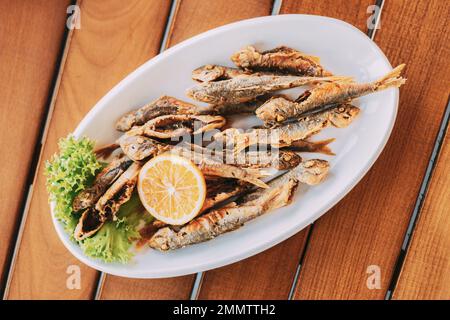 Plat avec poisson-mulet à l'orange. Friture de petits poissons frits Banque D'Images