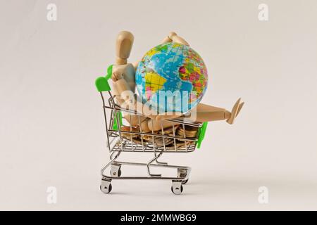 Mannequin en bois dans un panier avec globe terrestre - concept de protection de la Terre, mondialisation et économie Banque D'Images