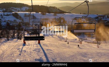 Station de ski, skieurs sur les remontées mécaniques, pins blancs à l'aube ou au coucher du soleil rose, Krahule Slovaquie Banque D'Images