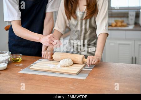 Un petit coup de pain fait une pâte crue pour une pâtisserie maison dans la cuisine, pétrir la pâte crue avec une broche à pâtisserie. cuisinez avec amour co Banque D'Images