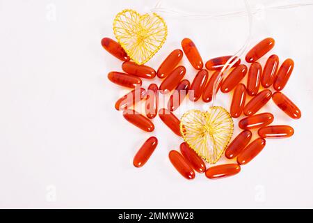 Vitamines pour le coeur, pour les enfants, les taylets sont dispersés sur la table. Additif alimentaire rouge, capsule, forme de coeur. Un mode de vie sain, la prévention des maladies. Photo de haute qualité Banque D'Images