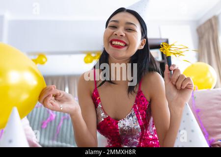 Bonne femme biraciale ayant la fête à la maison faisant des appels vidéo et souriant, espace de copie. Célébration, fête et concept de communication. Banque D'Images