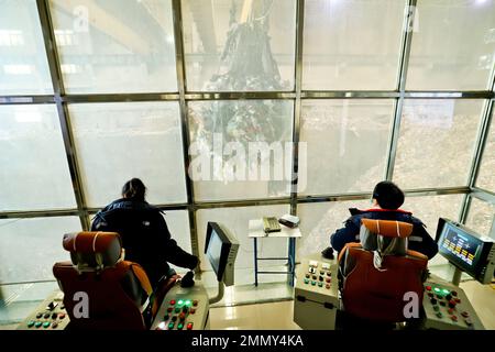ZHANGYE, CHINE - 29 JANVIER 2023 - les travailleurs utilisent une pince pour capturer les déchets et les placer dans une trémie de réception à la centrale de production d'énergie de biomasse de Zhangye de Huaxi Banque D'Images