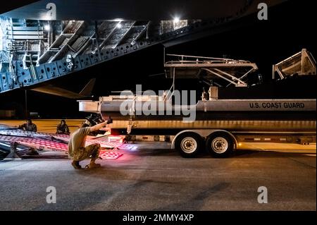 Des gardes-côtes américains de l'unité de sécurité portuaire 309 et des aviateurs américains du 375th Logistics Readiness Squadron chargent un bateau de sécurité portuaire transportable sur un C-17A Globemaster III sur la base aérienne Scott, Illinois, le 23 septembre 2022. Le PSU 309 peut être déployé dans le monde entier dans les 96 heures suivant le rappel et répondre aux missions nationales, y compris l'aide humanitaire. Banque D'Images