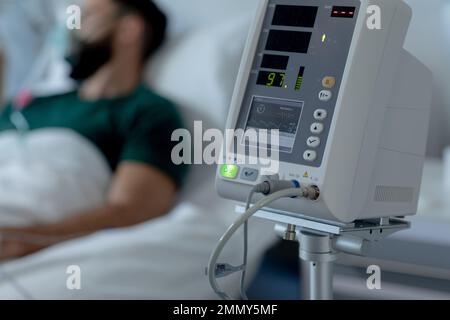 Un homme caucasien allongé au lit avec un masque à oxygène à l'hôpital Banque D'Images
